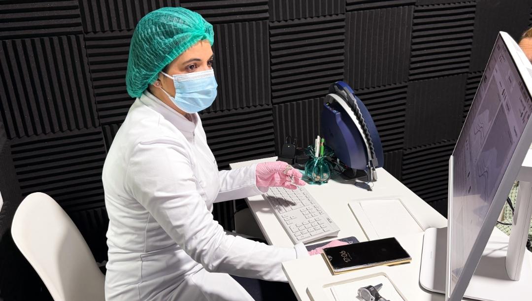 Roberta Paz programando audífonos en su cabina audiométrica