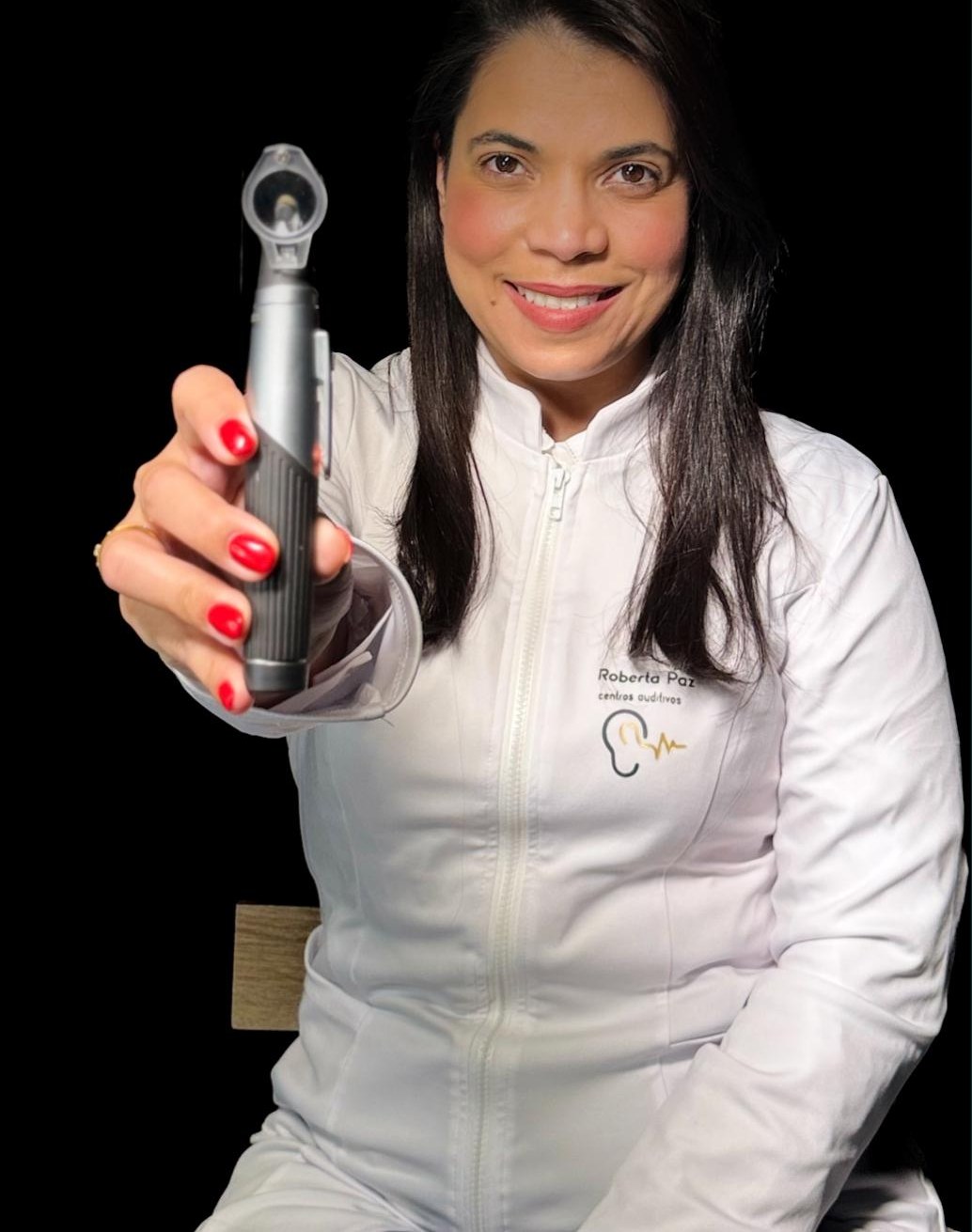 Roberta Paz mostrando un otoscopio, lista para tu revisión auditiva